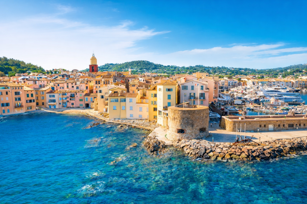Colorful harbor and marina in the South of France with pastel buildings and clear blue water along the Mediterranean coast
