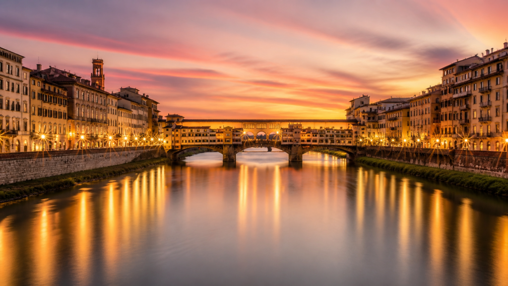 Sunset view of Florence in Europe with Ponte Vecchio over the Arno River and city lights reflecting on the water