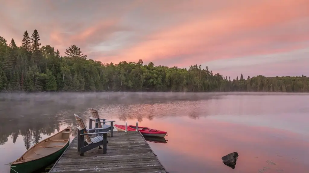Scenic lakefront view in Muskoka, Ontario with pine trees, calm water, and cottages
